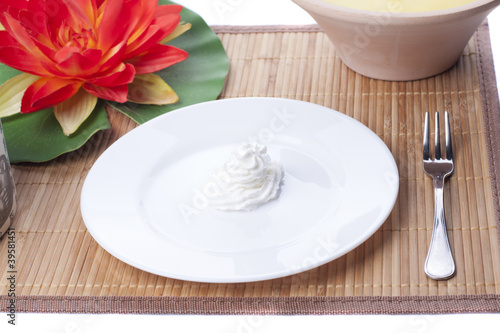 Shaped cream rose in a dish on straw mat
