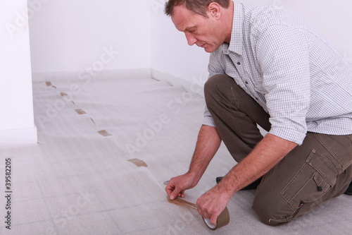 Εκτύπωση καμβά Man taping down underlay