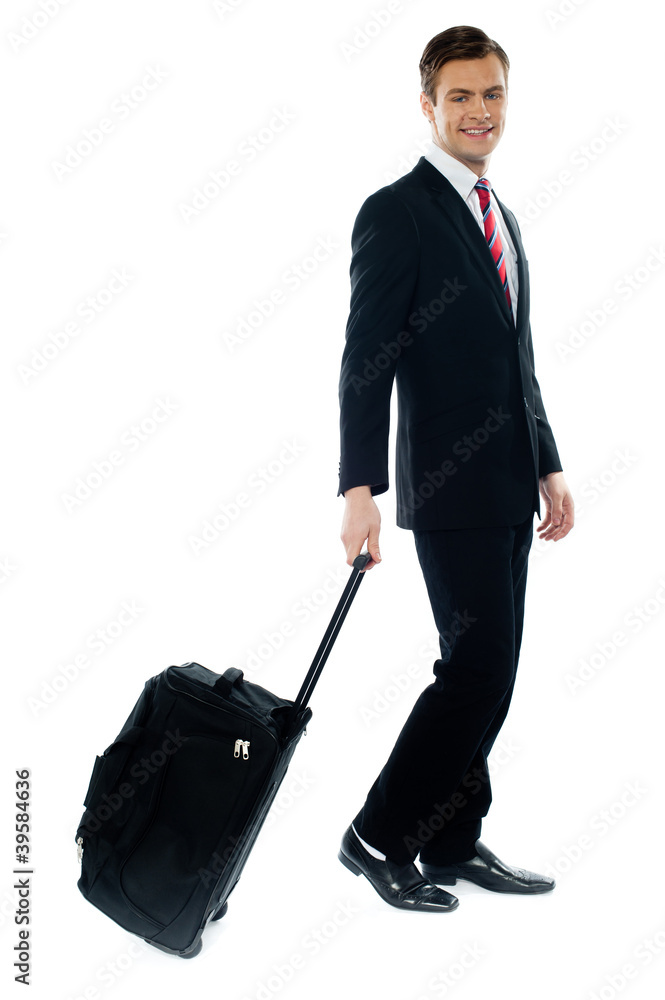 Handsome businessman dragging trolley bag Handsome businessman dragging trolley bag