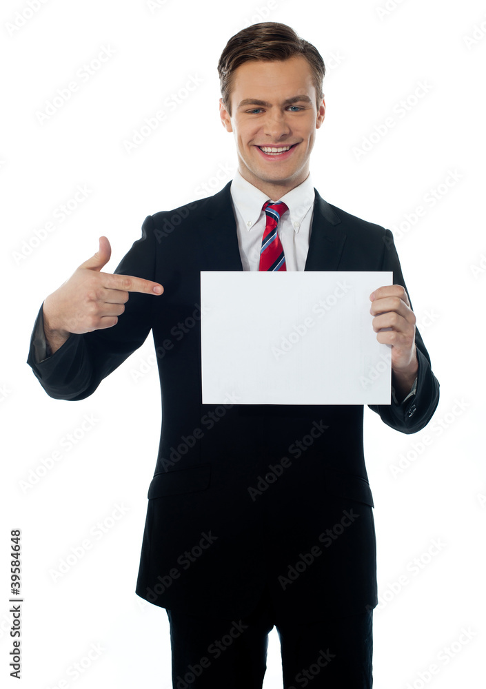 Young salesman pointing towards blank billboard Young salesman pointing towards blank billboard