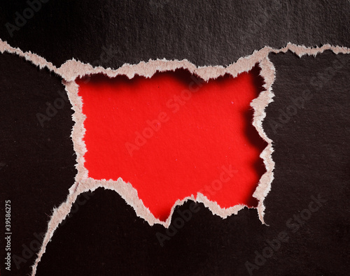 red hole with torn edges in...