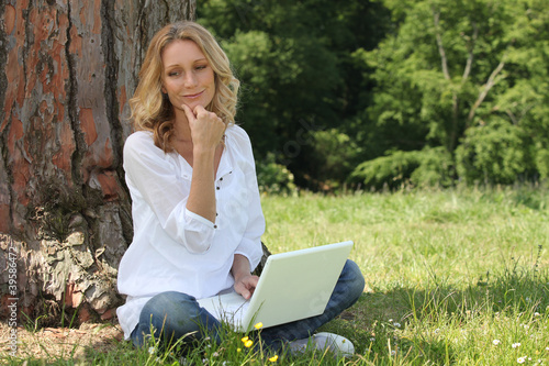 Woman using laptop in park © auremar