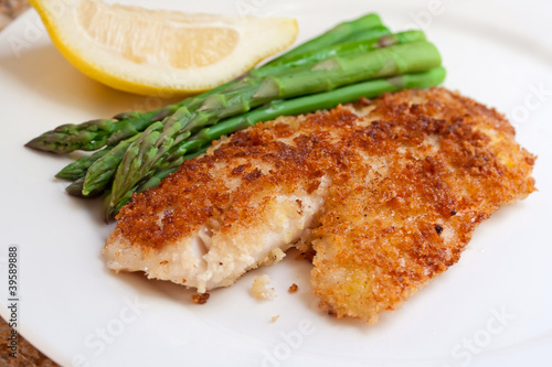 Fried breaded fish with asparagus and lemon