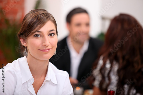 woman sitting in a restaurant with other diners photo