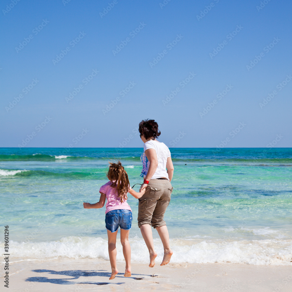 mother and daughter play together by the end of the ocean mother and daughter play together by the end of the ocean