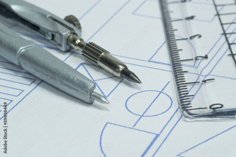 Close up image of a compass lying on building plans Close up image of a compass lying on building plans