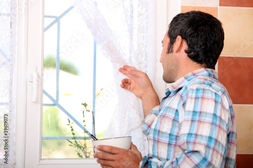 Man looking out window