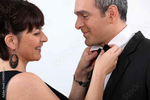 Tableau sur toile Woman in evening dress fixing her partner's bow tie