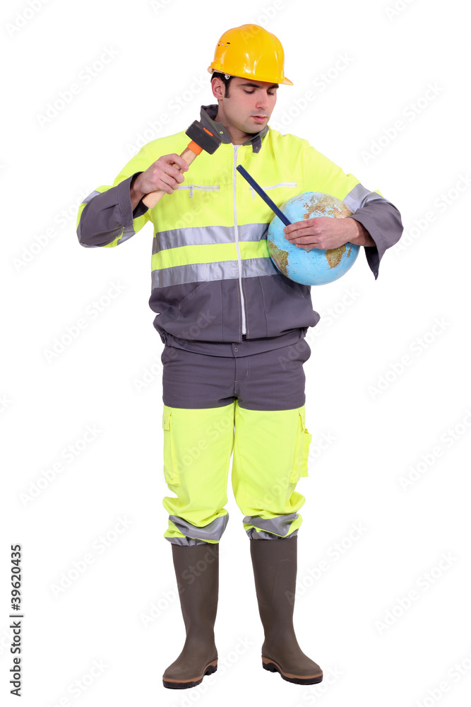 Builder using hammer and chisel on globe Builder using hammer and chisel on globe