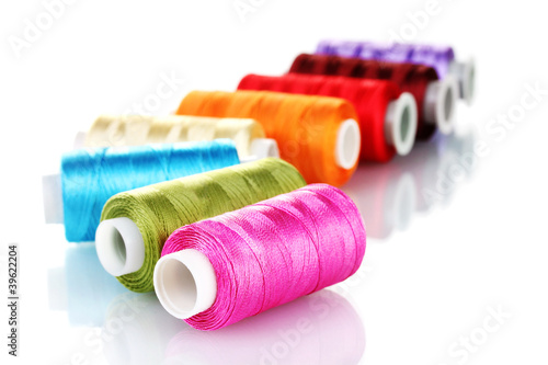 фотографія bright bobbin thread isolated on white.