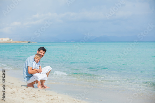 Happy father and his son playing at beach