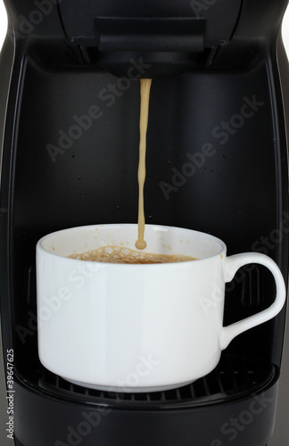 Espresso machine pouring coffee in white cup