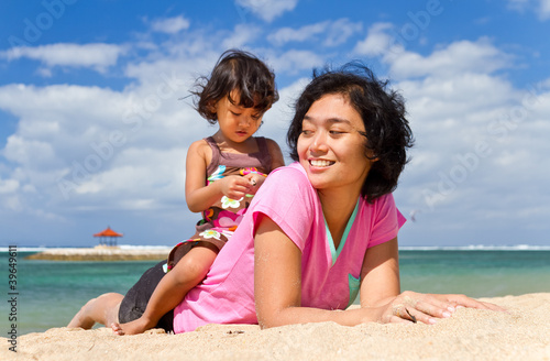Asian mother and child playing at the beach