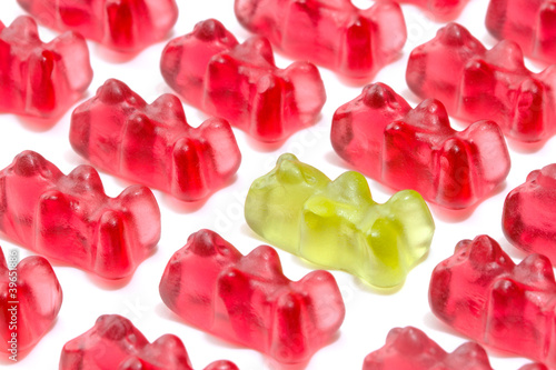 Green gummy bear among red