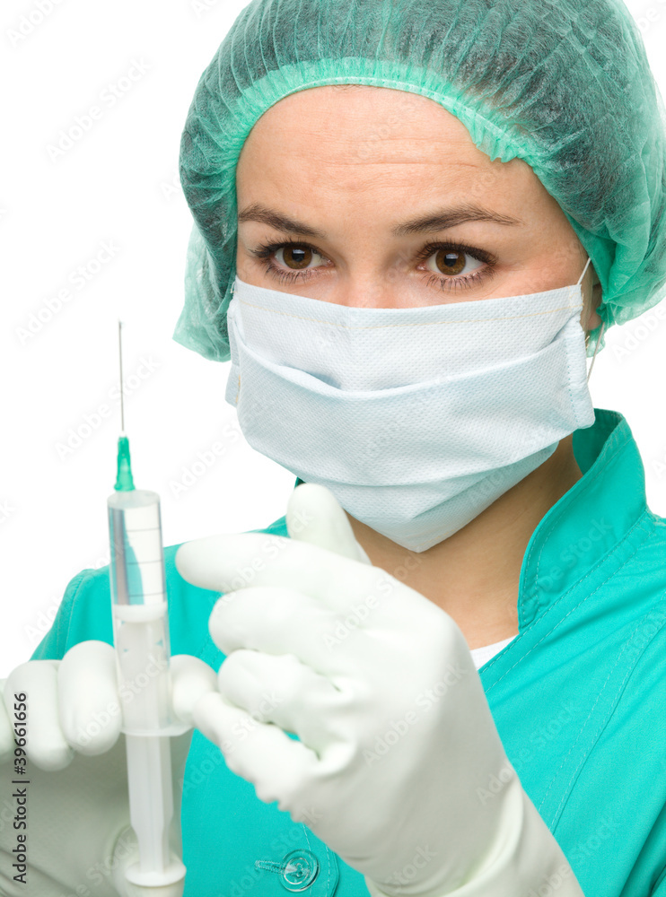 Young nurse is preparing syringe for injection Young nurse is preparing syringe for injection