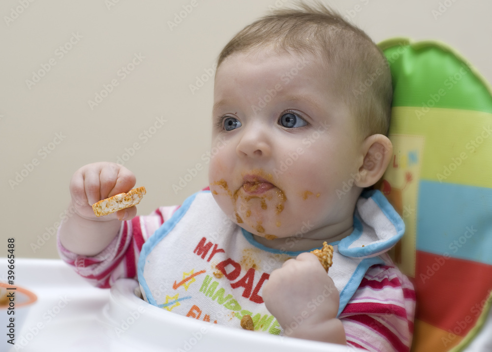 Nine month old baby learning to feed herself. Nine month old baby learning to feed herself.