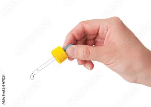Pipette in a hand of the person on a white background
