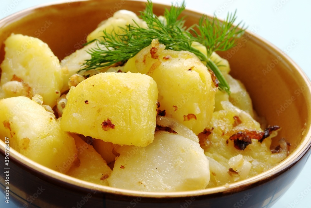 potatoes garnished with dill in a brown earthenware dish potatoes garnished with dill in a brown earthenware dish