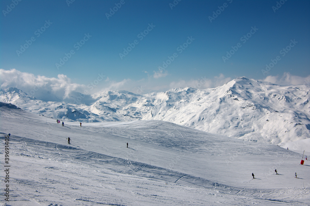 alpine skiers on long slopes in French Alps alpine skiers on long slopes in French Alps