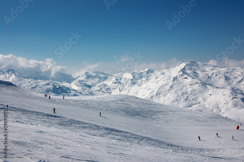 alpine skiers on long slopes in French Alps