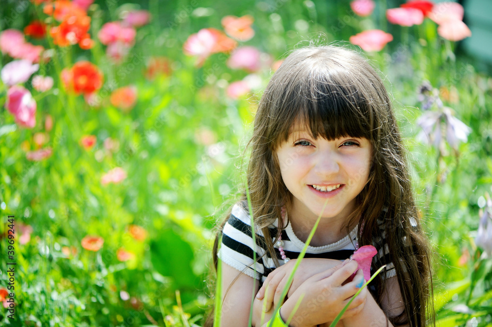 Smiling little girl sitting on poppy field Smiling little girl sitting on poppy field
