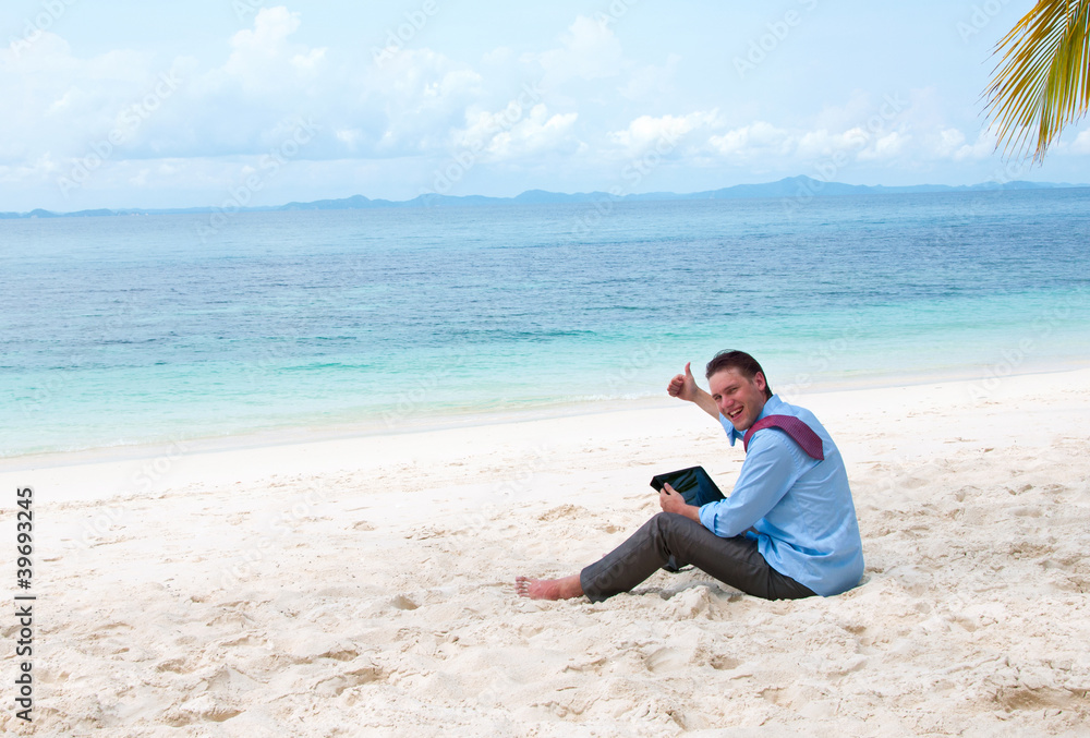 Happy business man  on the beach with tablet computer