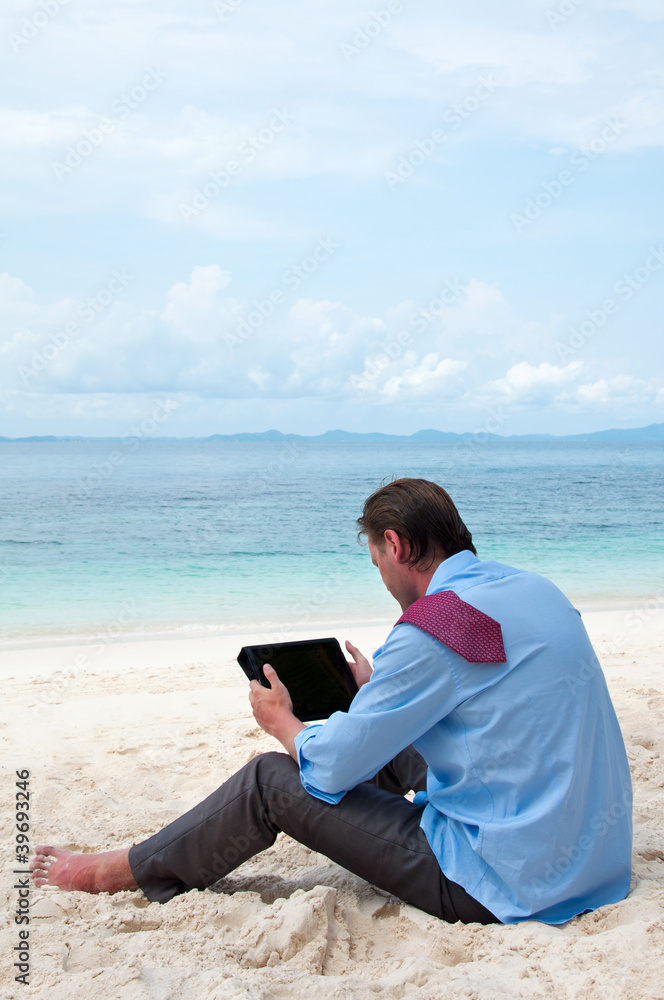 Business man working on the beach with tablet computer