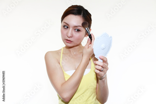 化粧をする女性 © sunabesyou