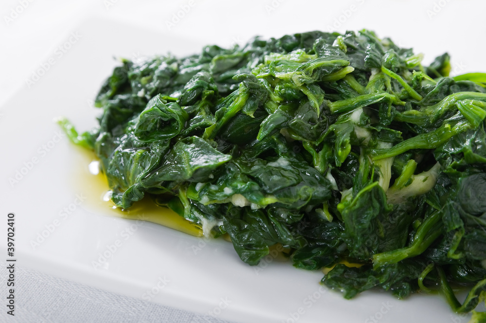Boiled spinach on white dish. Spinaci bolliti. Boiled spinach on white dish. Spinaci bolliti.