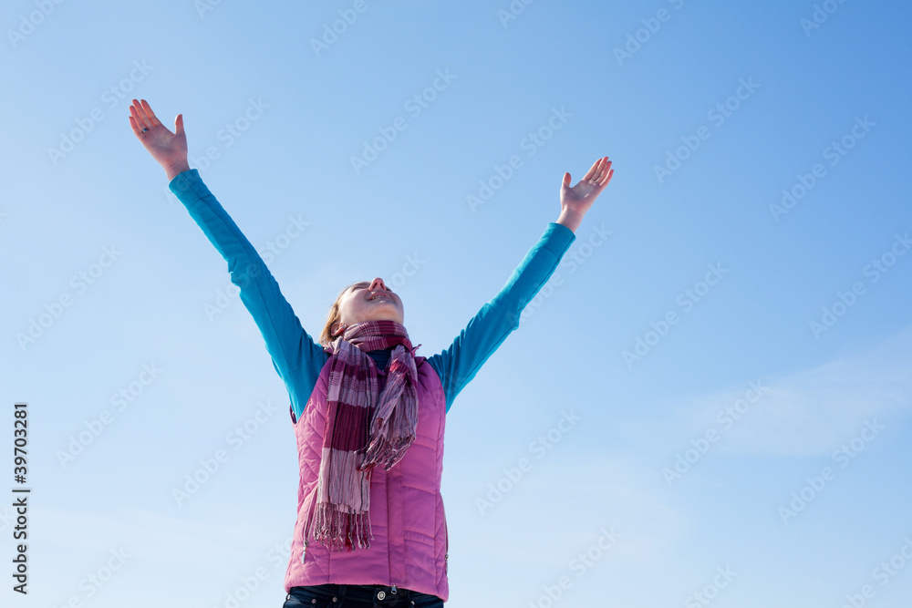 Teen girl staying with raised hands