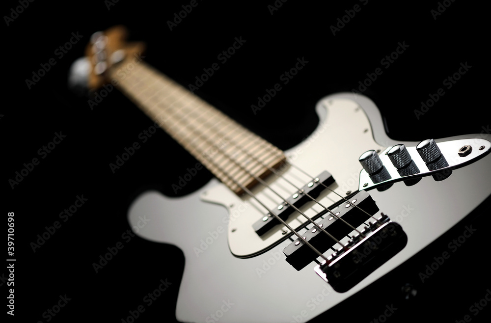 Fototapeta premium close up of a black electric bass glossy on dark background