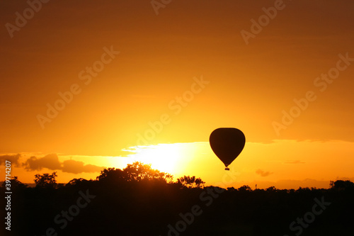 Hot air balloon flying at sunrise over Masai Mara Park, Kenya