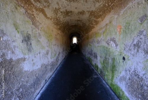Scary old tunnel and pathway with distant exit..