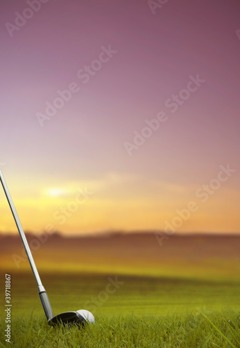 hitting golf ball along fairway at sunset