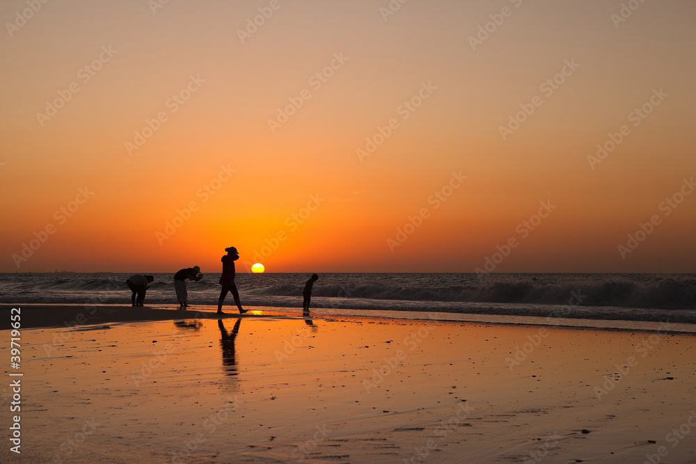 The silhouettes of people at the sunset background