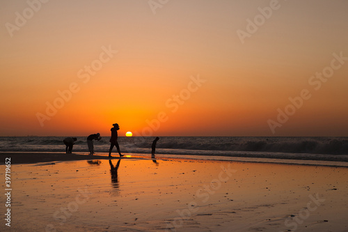 The silhouettes of people at the sunset background