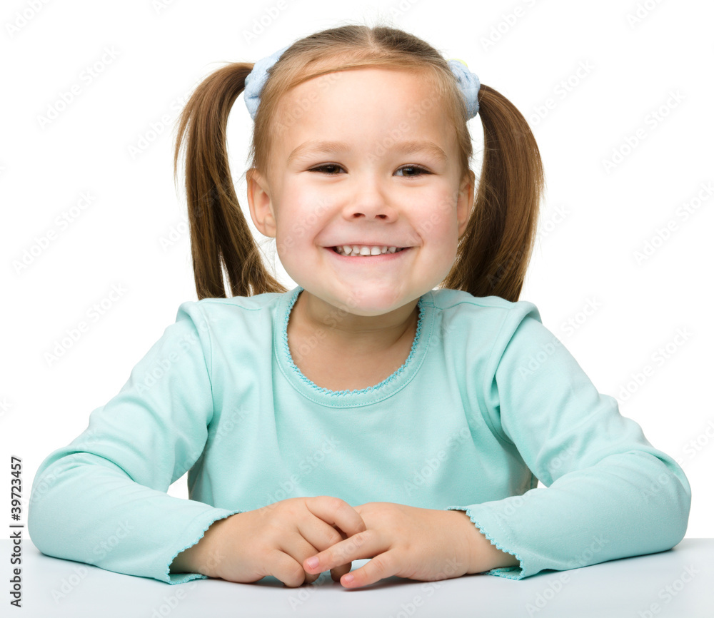 Happy little girl is sitting at the table Happy little girl is sitting at the table