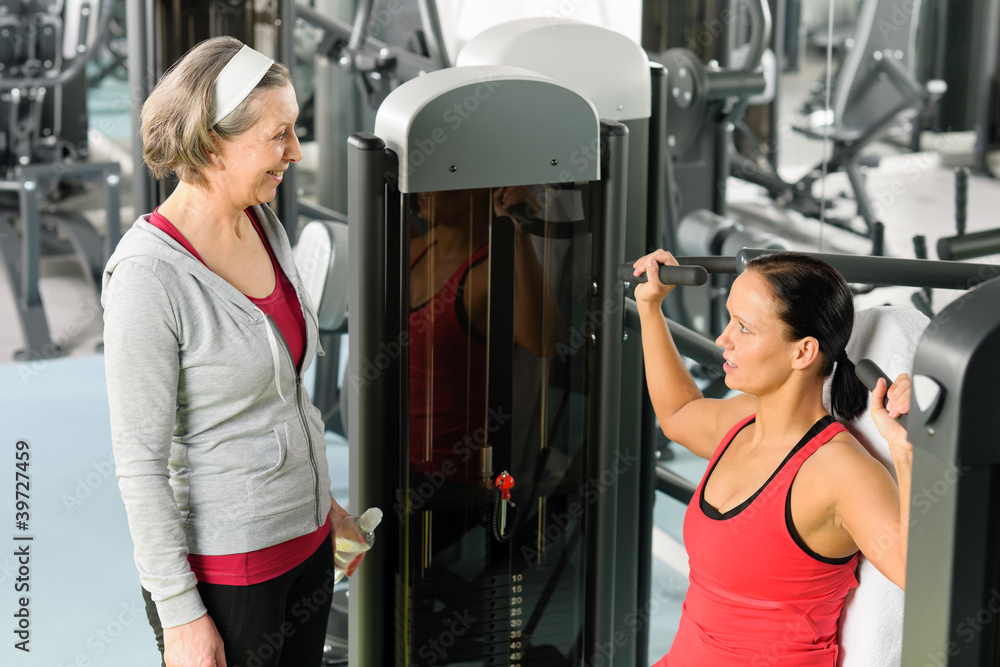 Personal trainer at fitness center showing exercise Personal trainer at fitness center showing exercise