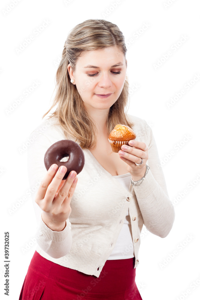 Hungry woman holding sweet muffin and donut