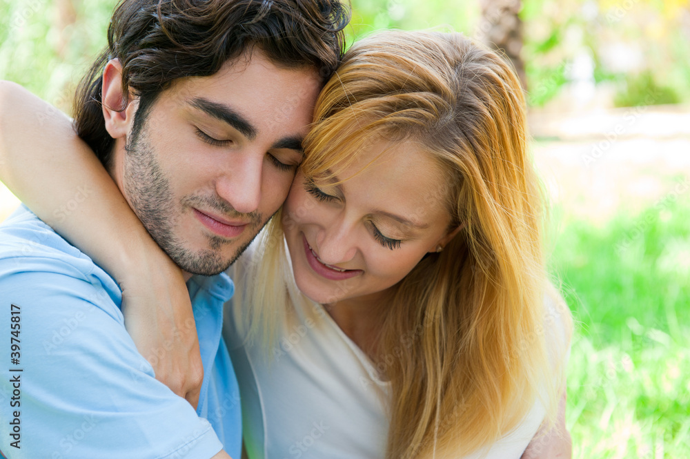 Romantic young couple sitting together in summer park Romantic young couple sitting together in summer park