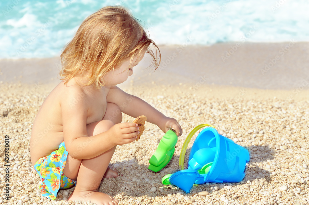 Happy child on the beach playing with her toys Happy child on the beach playing with her toys