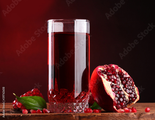 ripe pomergranate and glass of juice photo