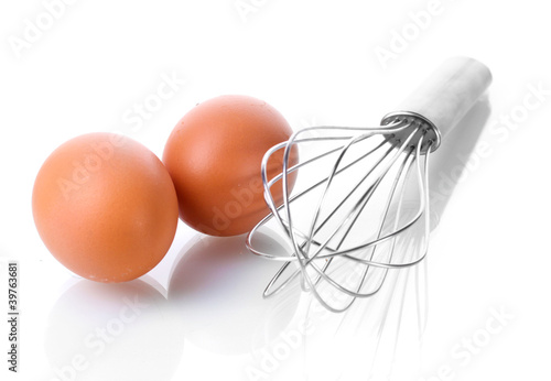 Fototapeta Metal whisk for whipping eggs and brown eggs isolated on white