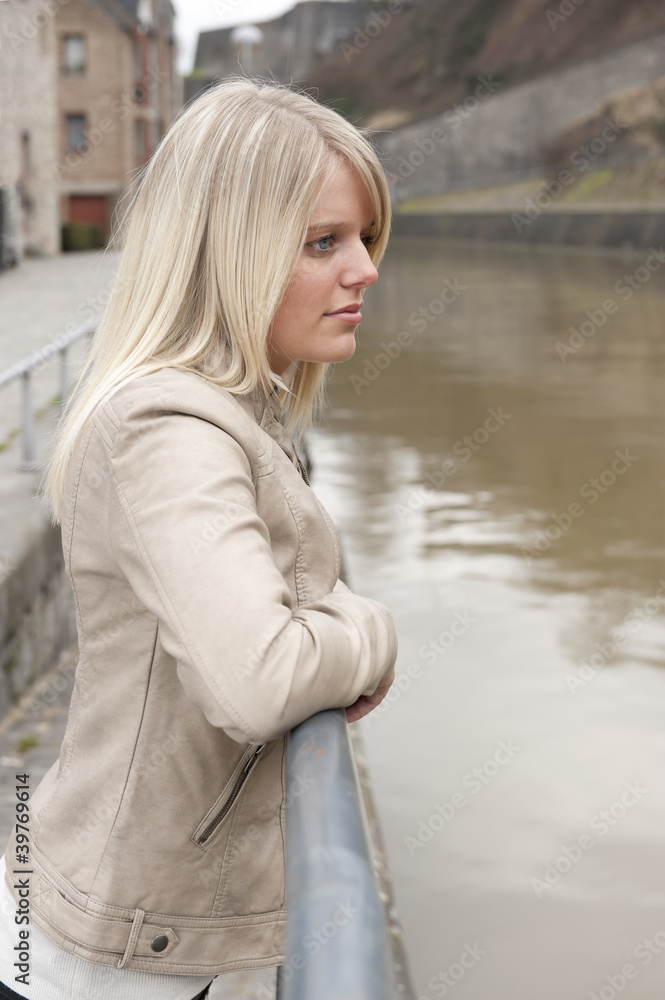 young blonde woman looking at the river