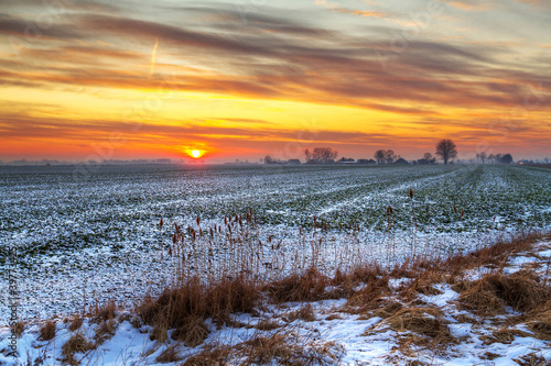 Idyllic sunset over snowy meadow in Poland