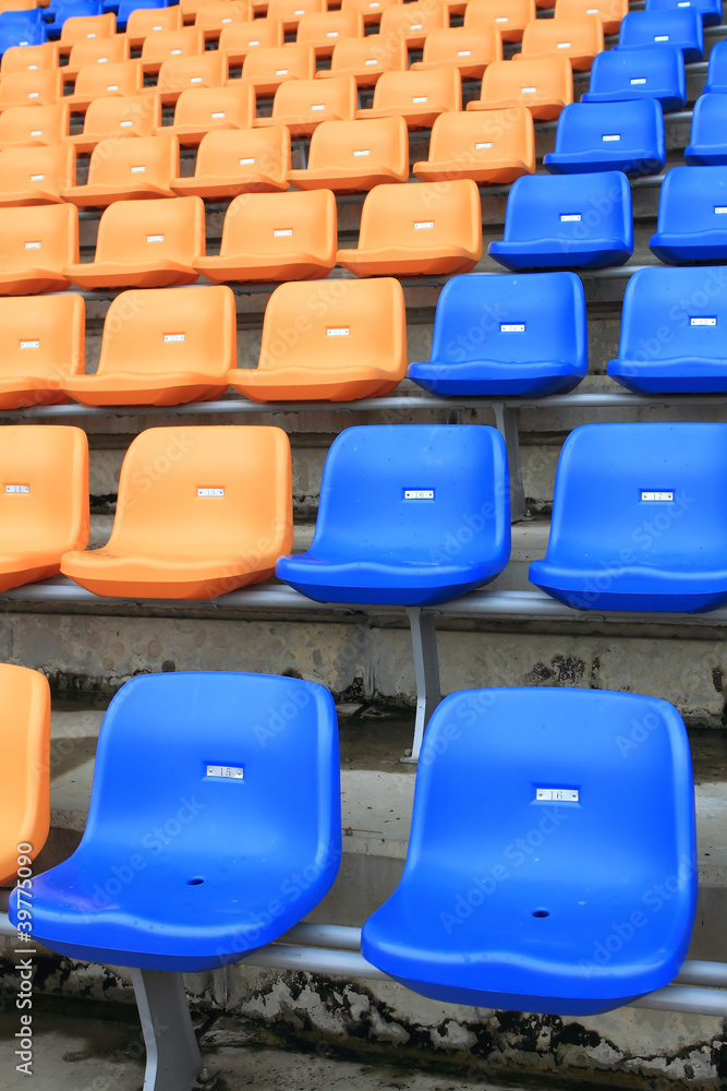 Naklejka premium plastic, yellow and blue, new chairs in stadium.