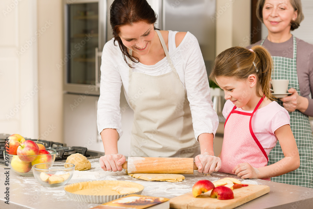 Mother and daughter making apple tart together