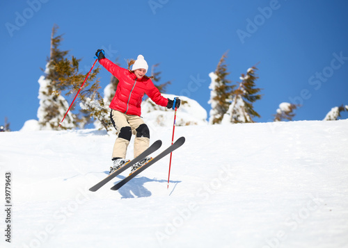 Young female skier jumping on snowy slope