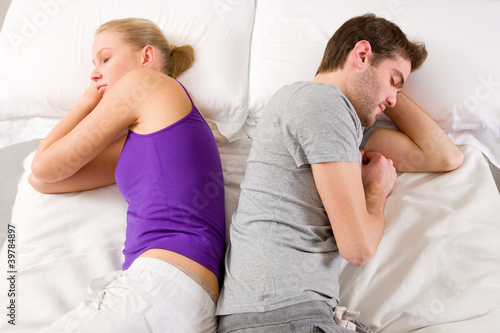 couple lying in bed back-to-back