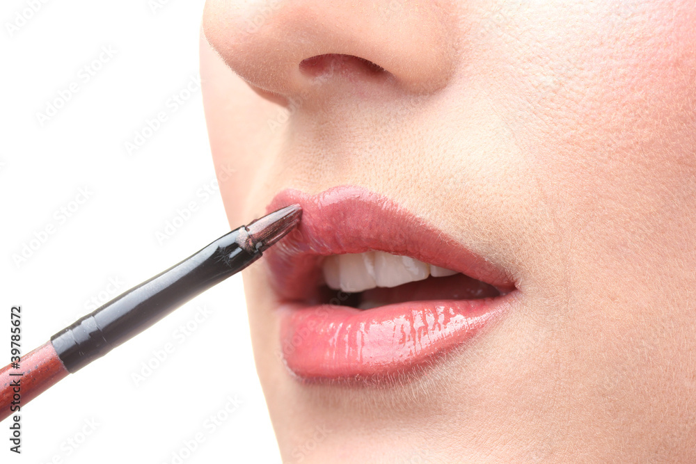 Naklejka premium beautiful woman applying lip gloss